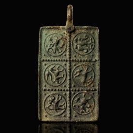 Medieval bronze harness pendant with a princely and protective bestiary
