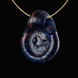Late Roman bi-coloured glass amulet pendant with Lion