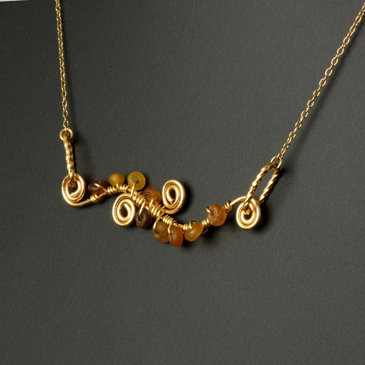 Necklace with wire-wrapped Roman amber glass beads and spiral details