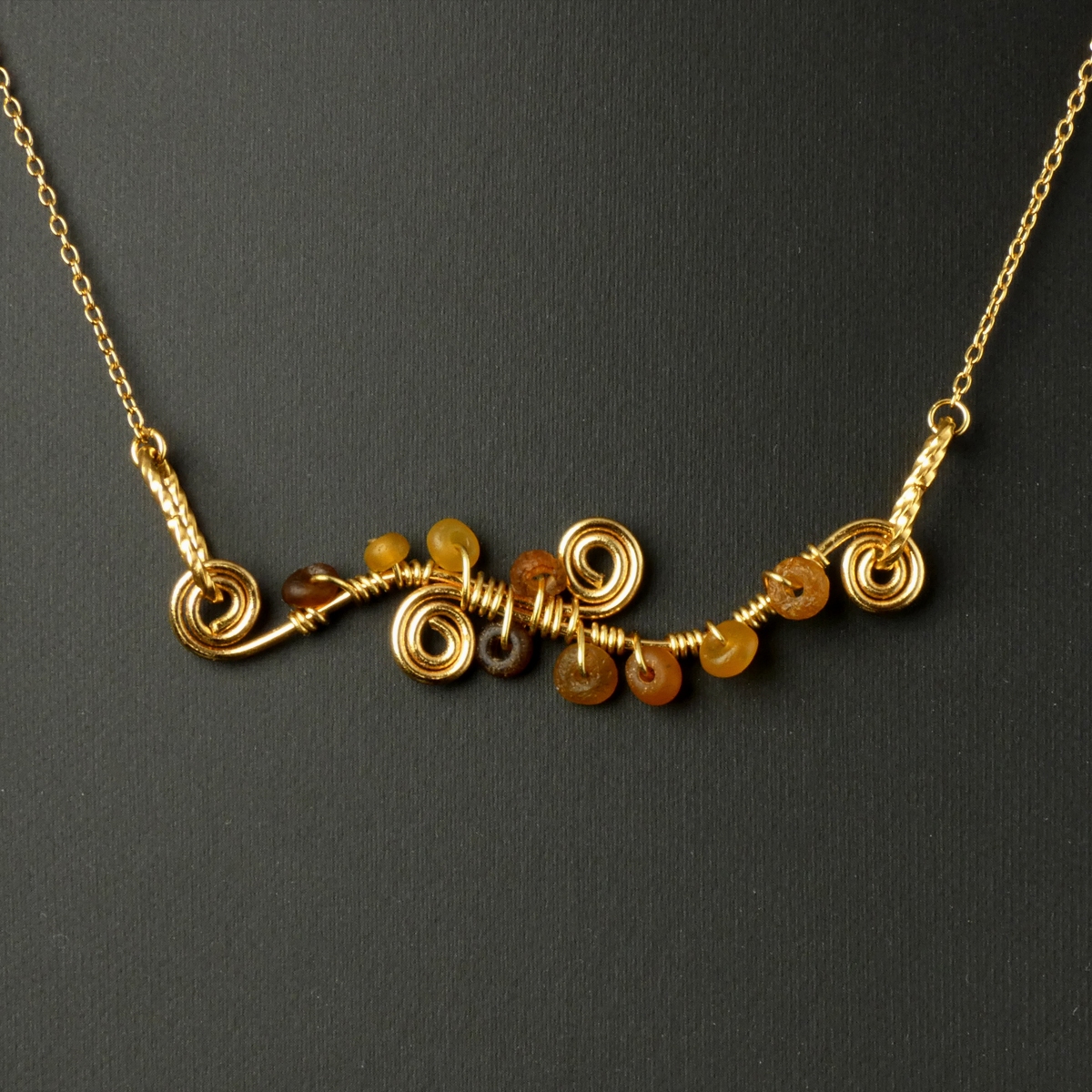 Necklace with wire-wrapped Roman amber glass beads and spiral details