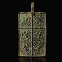 Medieval bronze harness pendant with a princely and protective bestiary