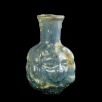 Roman Janus head glass bottle